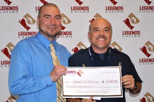 Legends Operations Manager Carlos Villareal presents YFD Captain Tom Schneider a check